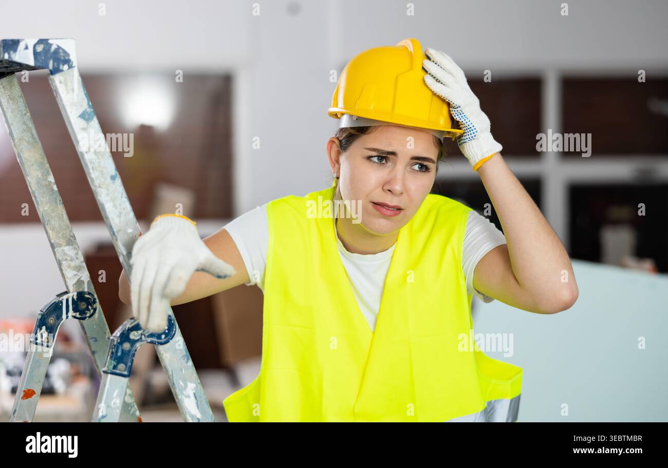 Sad woman builder standing in construction site Stock Photo