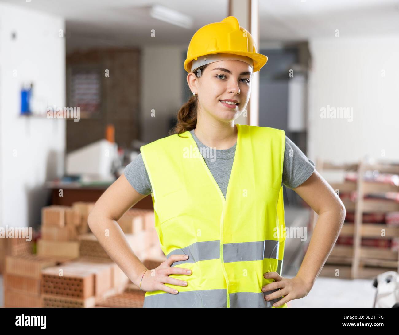 Young woman construction worker standing inside apartment Stock Photo