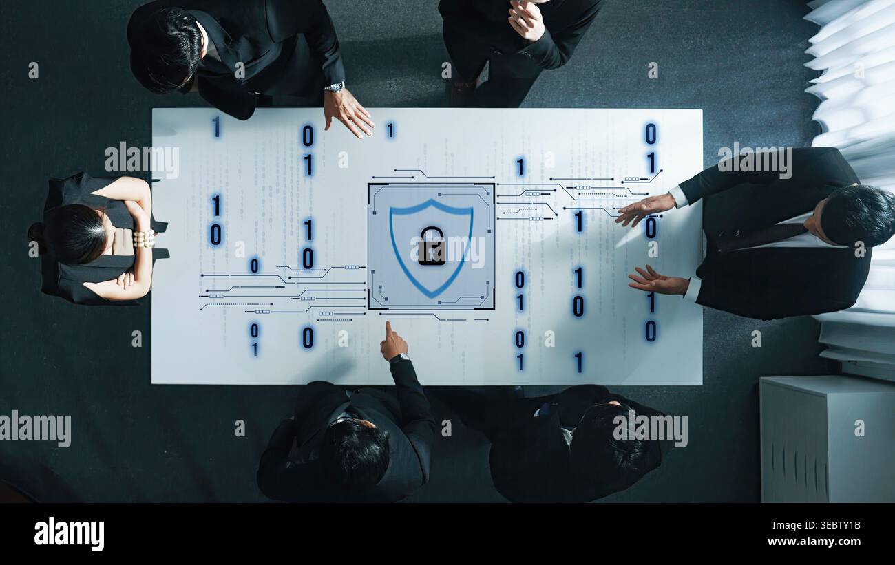 A business team collaborates on cybersecurity strategy, focusing on a digital lock design on the table surrounded by binary code, emphasizing data Stock Photo