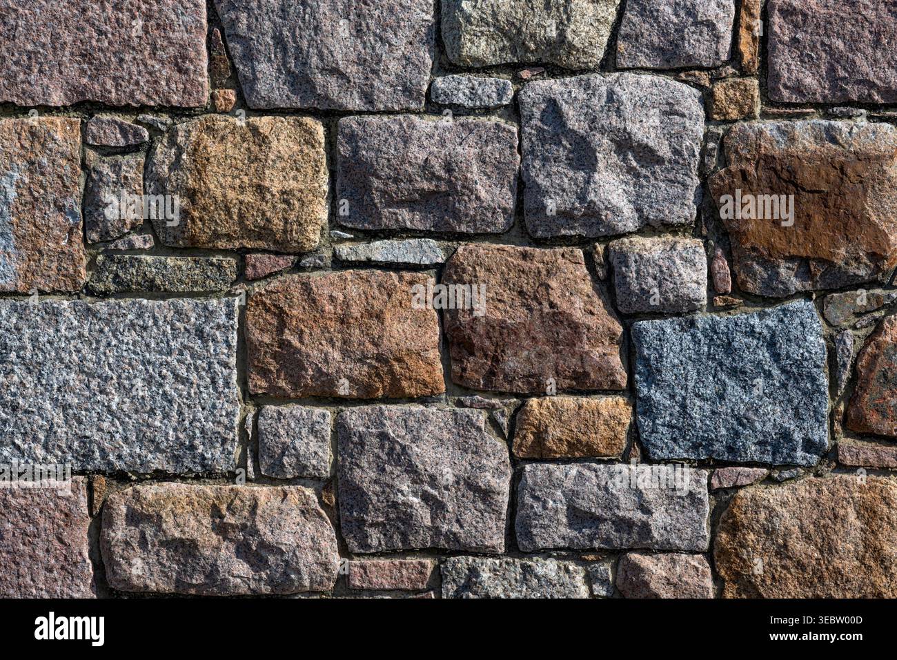 Rough granite stone wall for use as a background texture Stock Photo