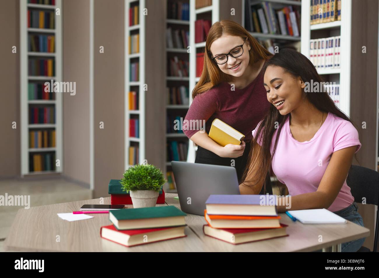 Students Collaborating on a Project in a Cozy Library Study Room Stock Photo