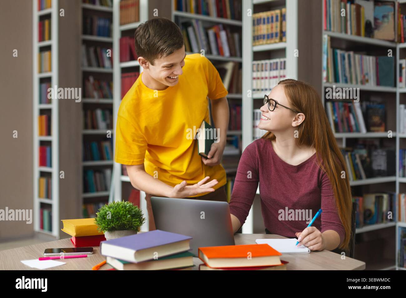 Students Collaborate on Study Project in a Library Setting During Daytime Stock Photo