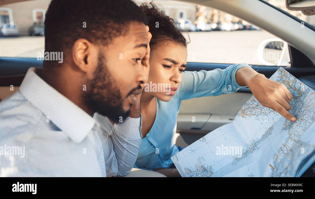 Couple Exploring Travel Plans While Sitting in Car Using a Map Stock Photo