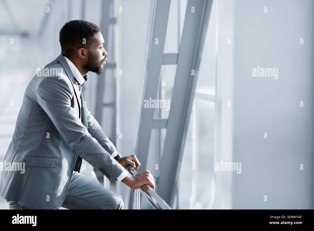 Feeling Relaxed. Confident Businessman Looking Through Window Stock Photo