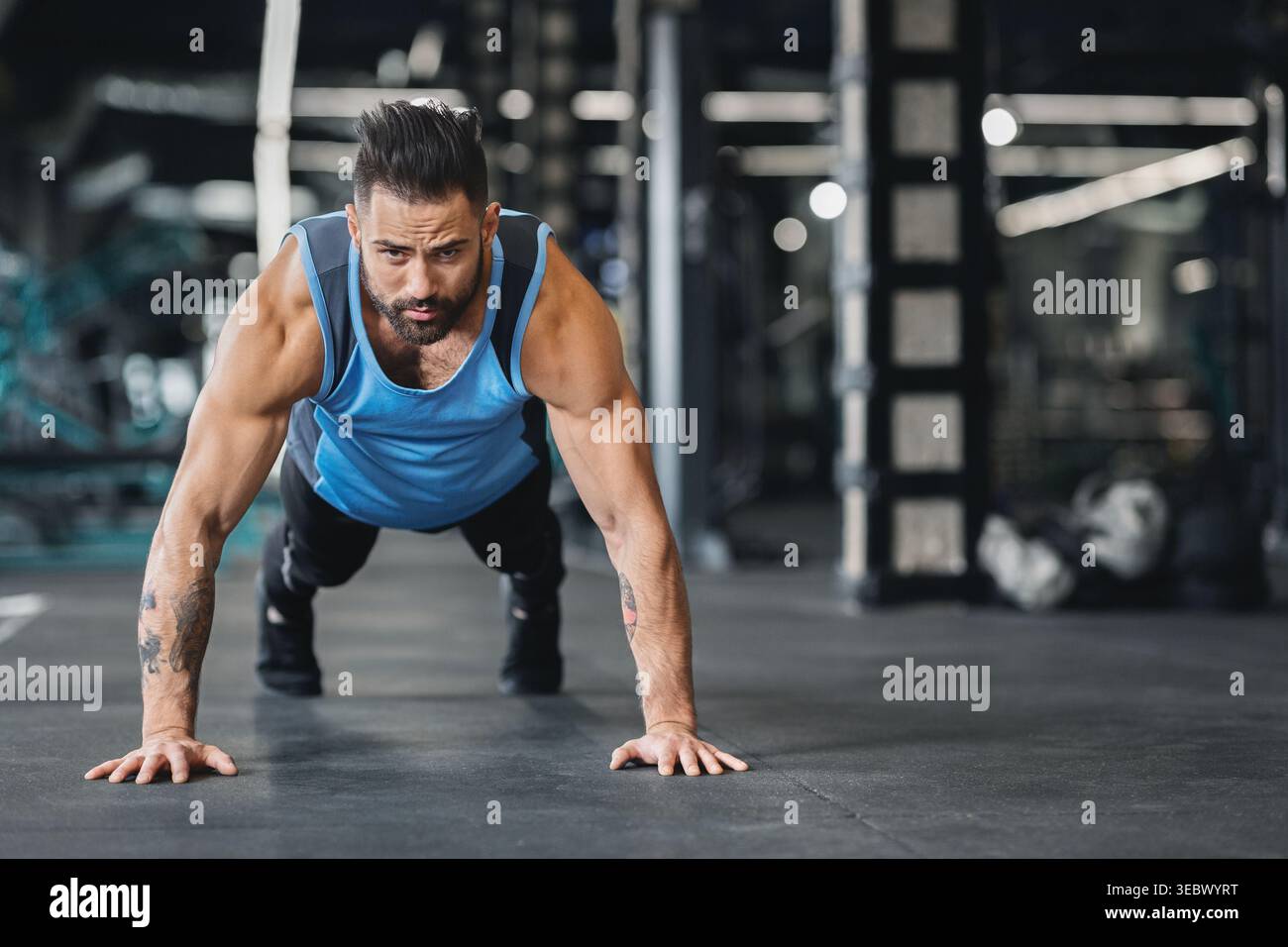 Concentrated muscular guy doing push up exercises Stock Photo