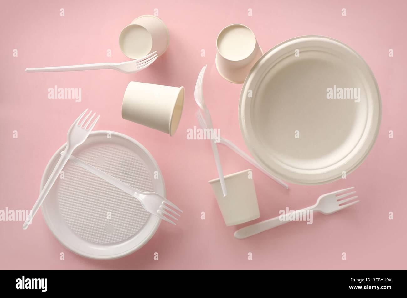 White plastic tableware levitating on pink background Stock Photo
