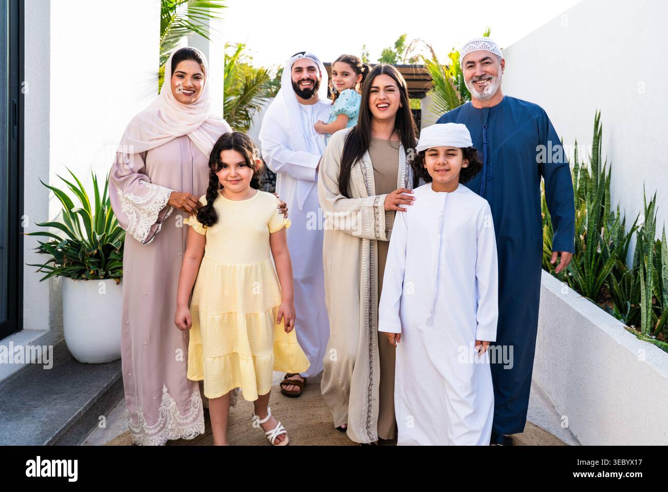 Arab family standing together outside their home, including parents ...