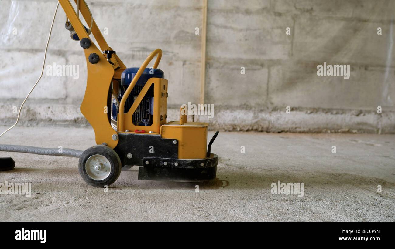 Worker Grinding Concrete Floor With Machine Stock Photo
