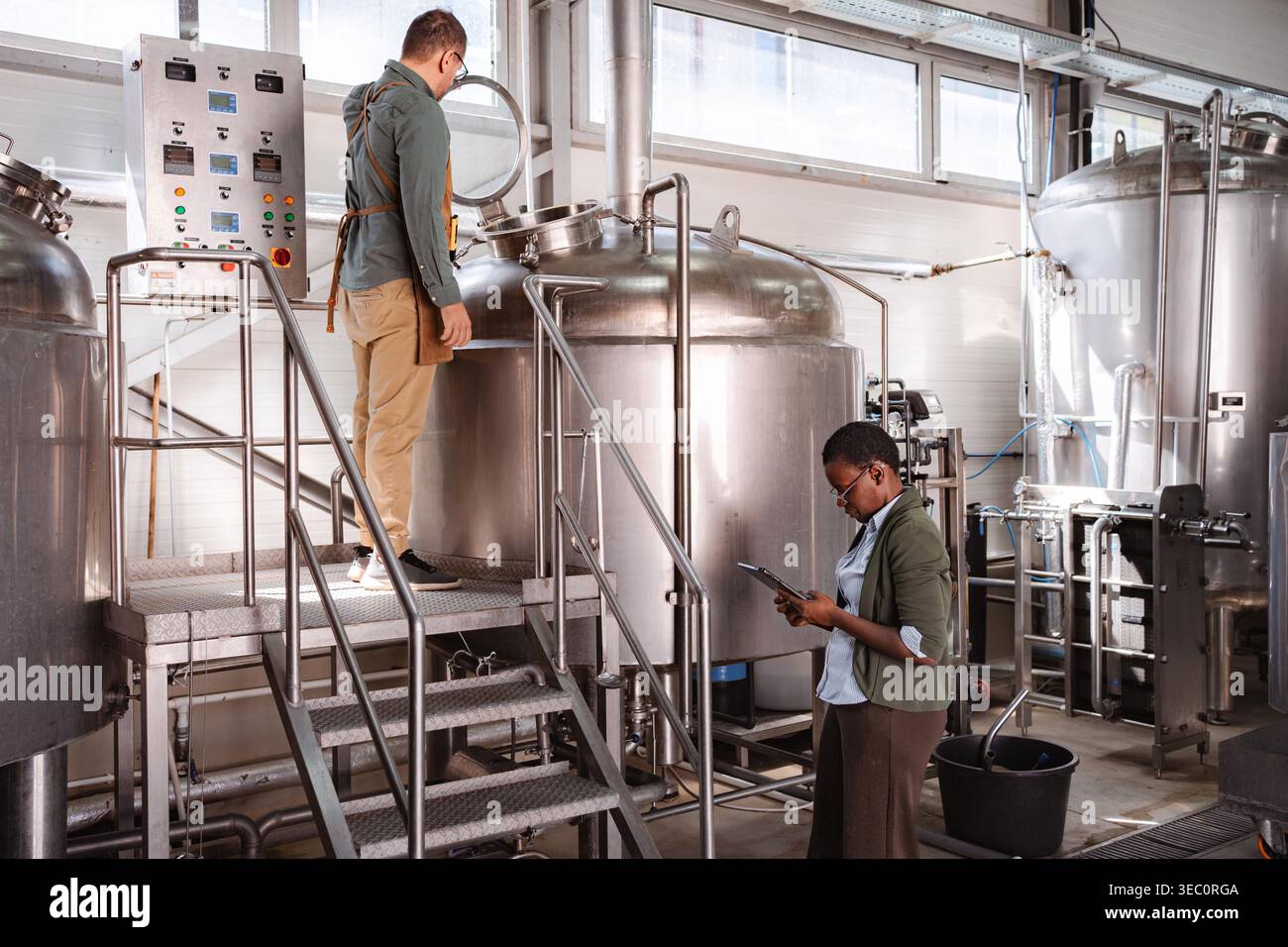 Factory workers checking manufacturing process in a modern craft beer brewery Stock Photo