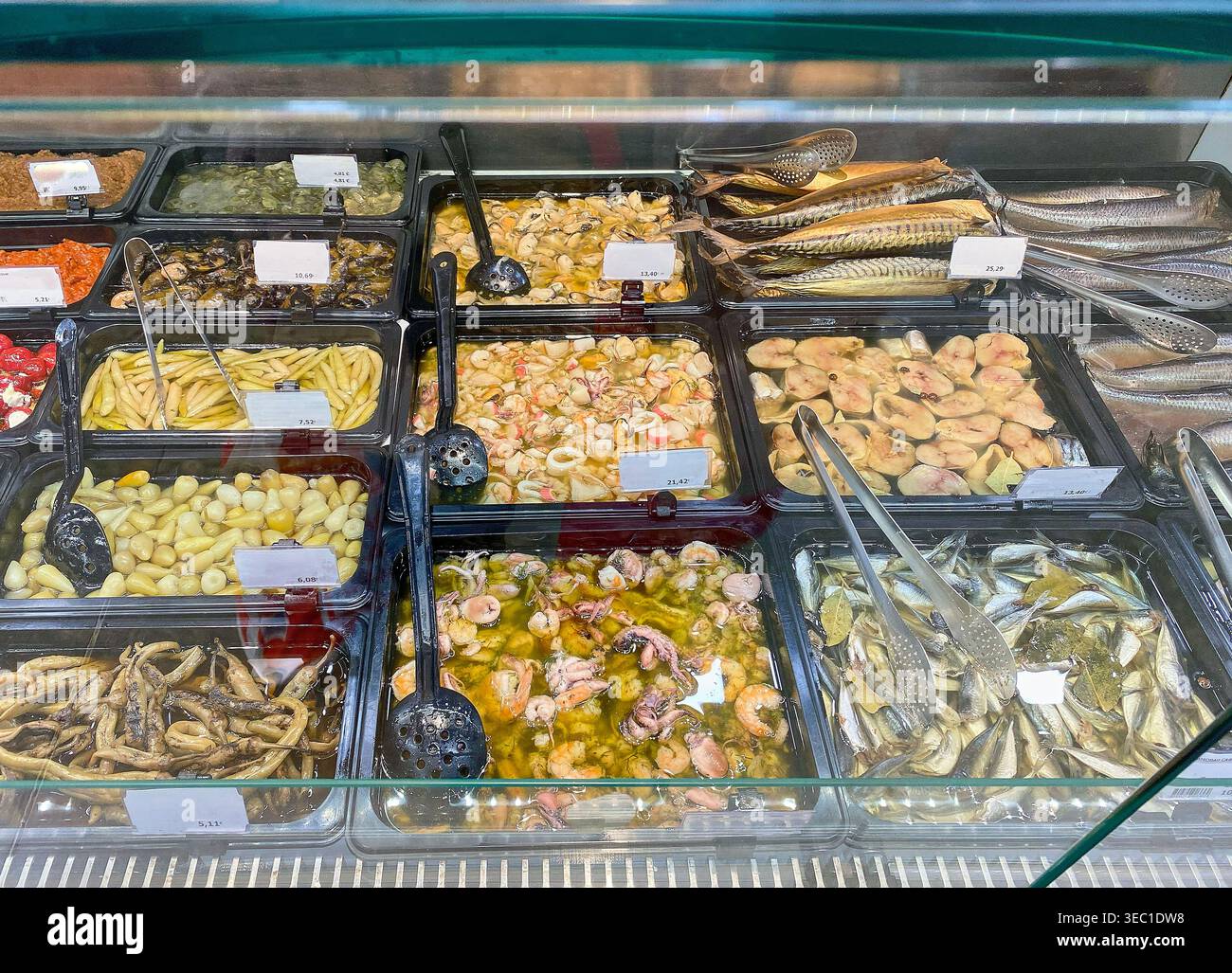 Display of assorted seafood in a refrigerated counter, including ...