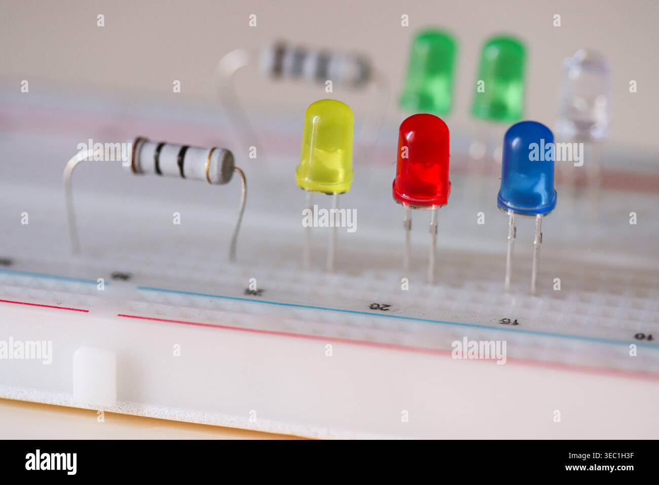 Electronics prototyping with LEDs and resistor on breadboard, close-up circuit components Stock Photo