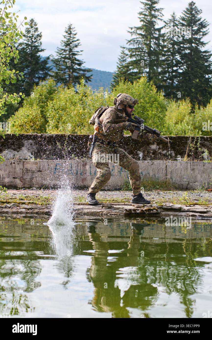 Solier Ranning Soldier in Camouflage Running Along Water's Edge With Rifle During ...