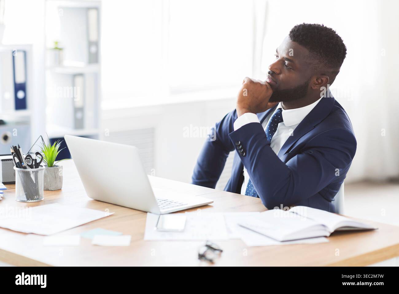 Thoughtful businessman making business solution at workplace Stock Photo