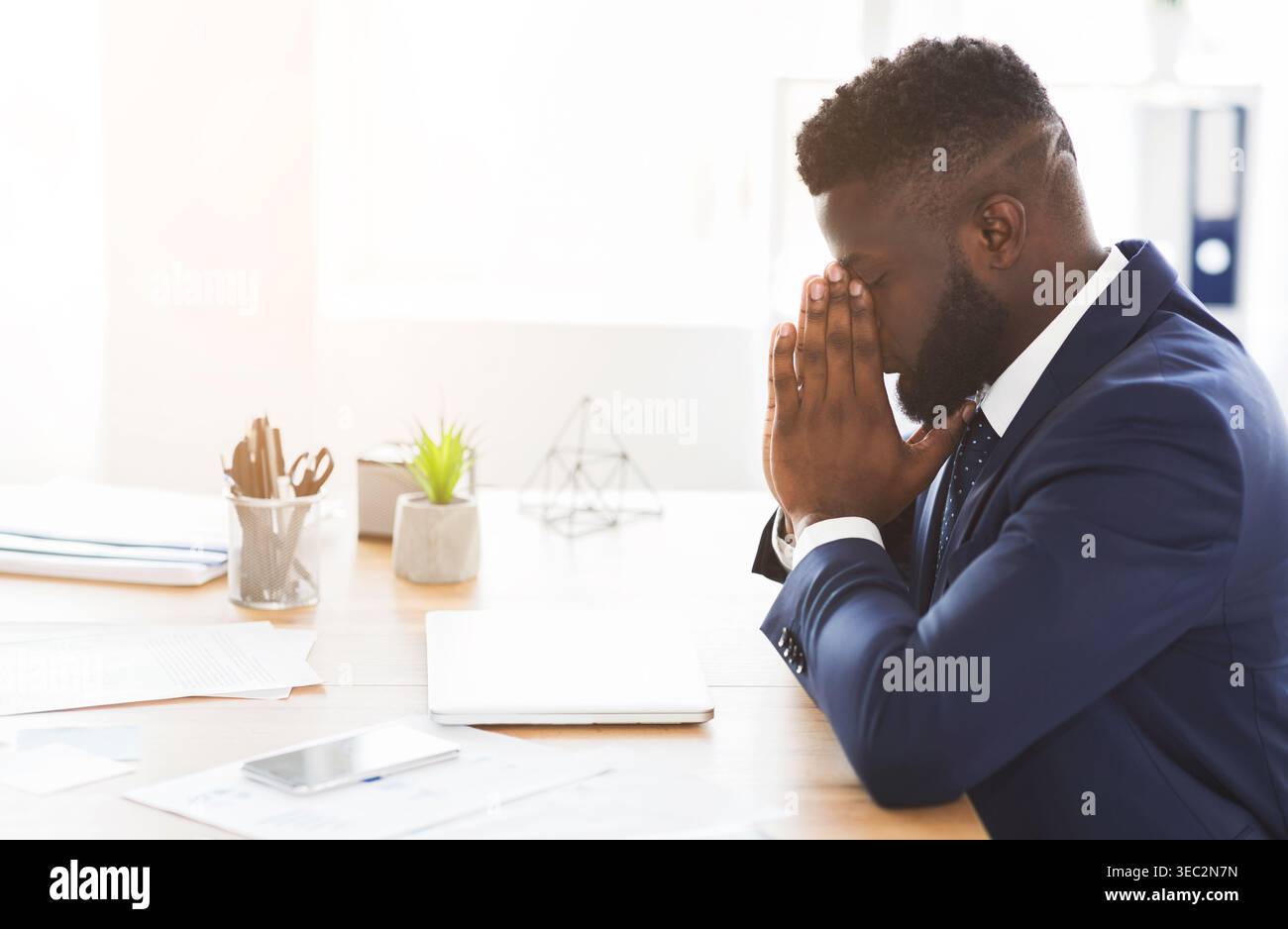 Young exhausted businessman having stress at work Stock Photo