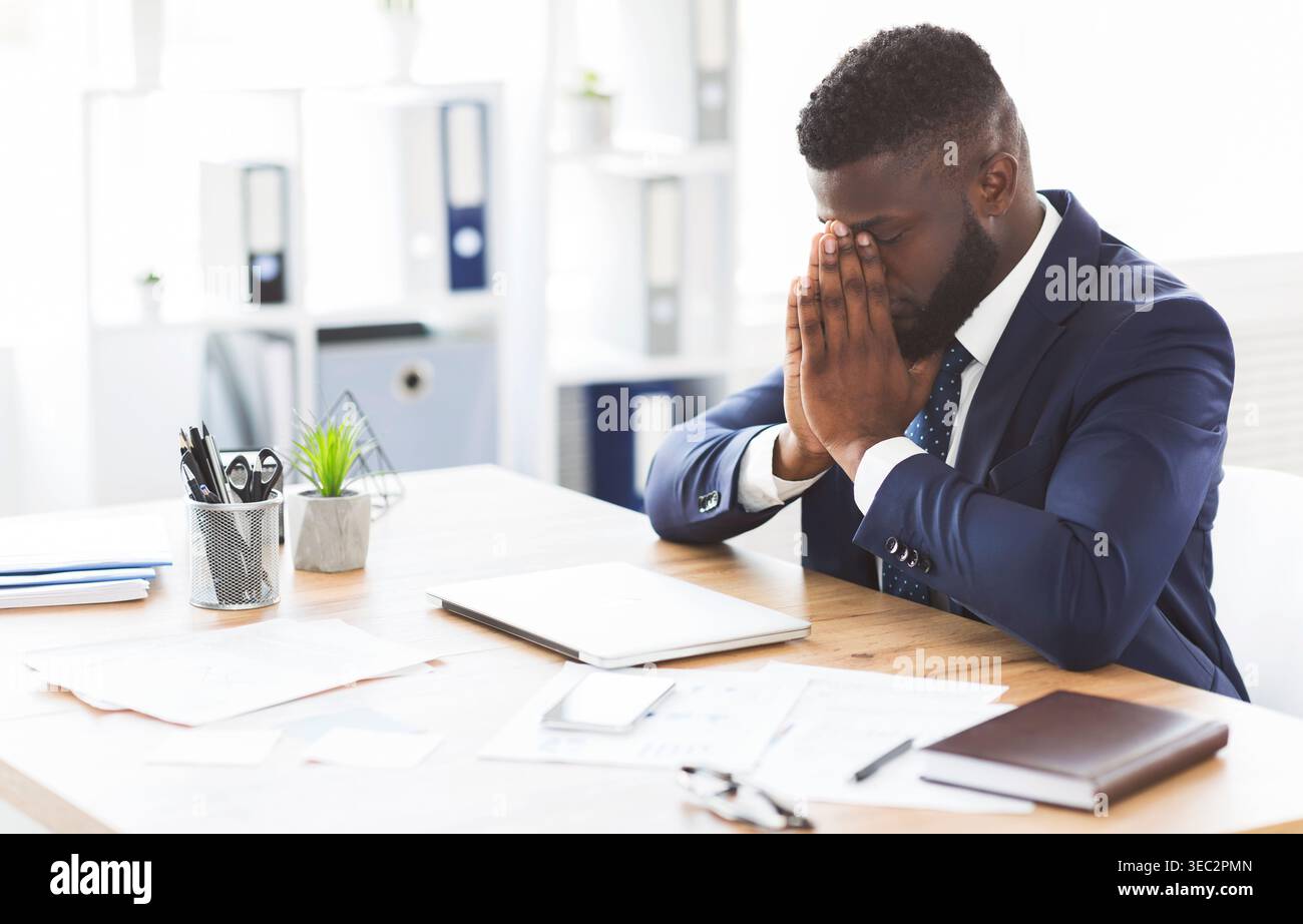 Young tired businessman having stress at work Stock Photo