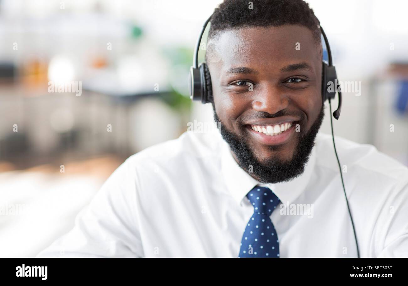 Smiling Customer Service Representative Wearing Headset in Modern Office Setting Stock Photo