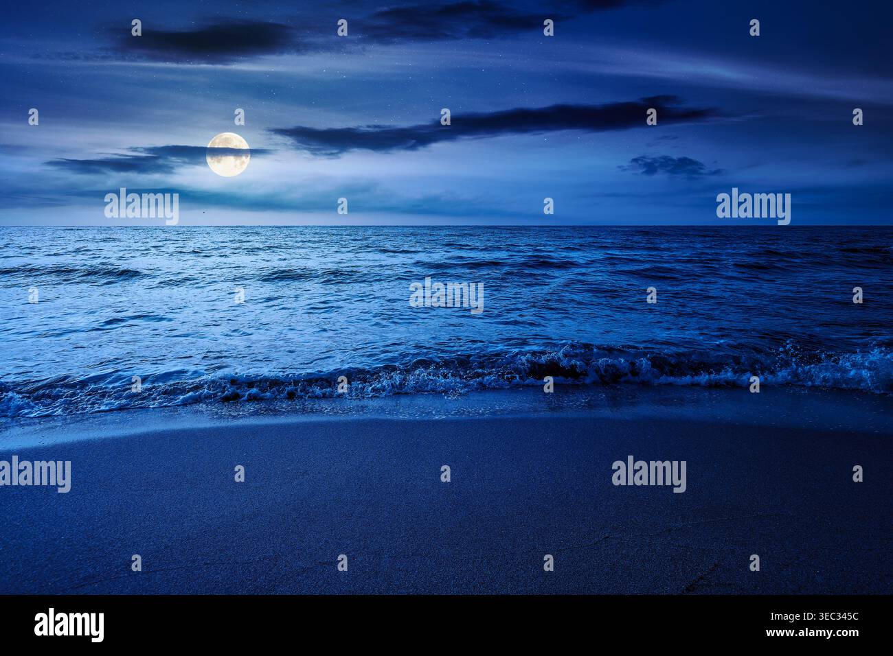 autumn vacation at the sea at night. full moon over beautiful seascape. calm waves wash the sandy beach. image with cloudy sky above horizon. mysterio Stock Photo