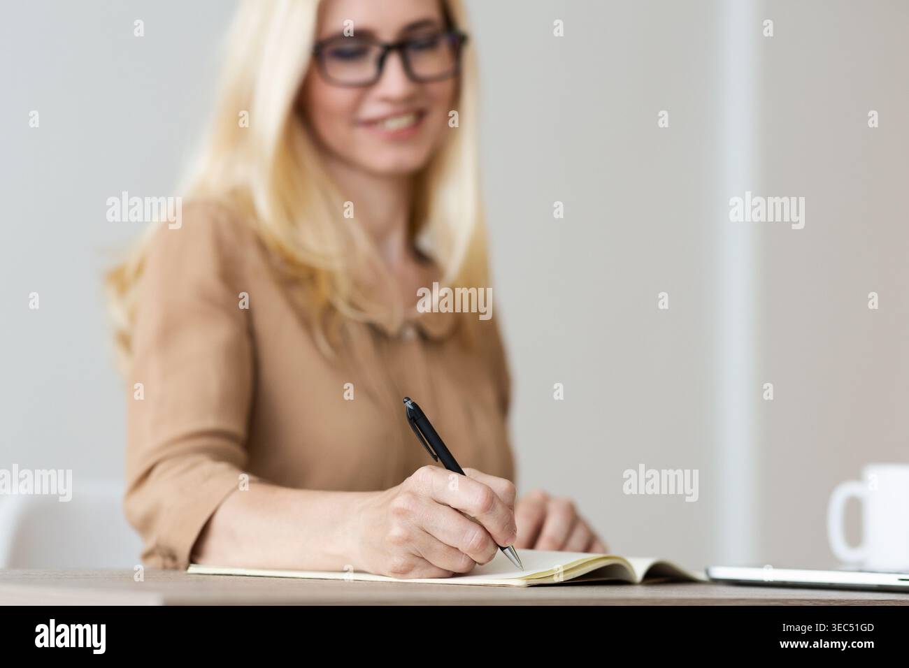 Mature Freelancer Writing Down Plans Project Into Notebook Stock Photo