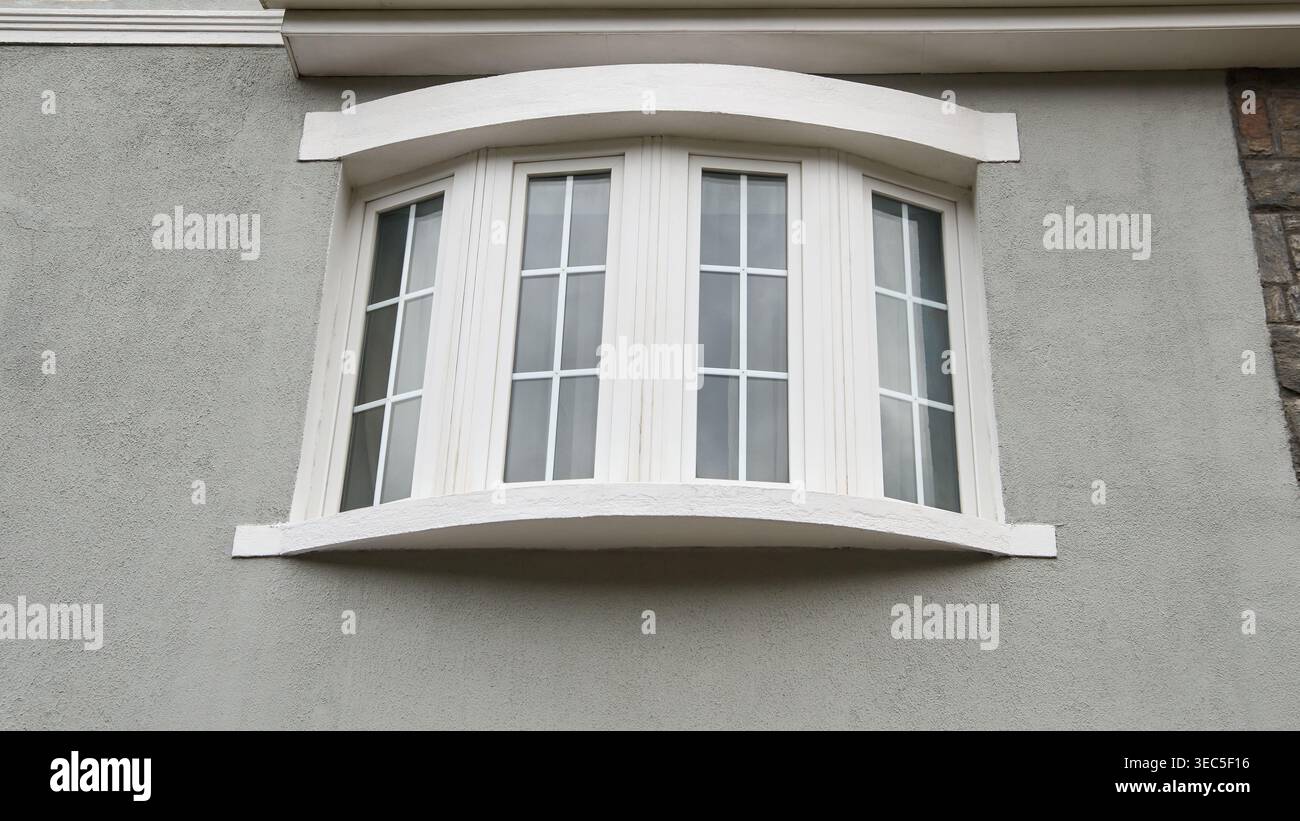 Upper Rear Window four panel curved white bay window on grey stucco wall, architectural ...