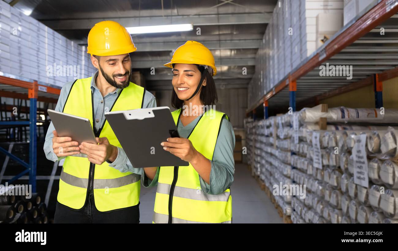 Two warehouse workers collaborating on inventory control Stock Photo