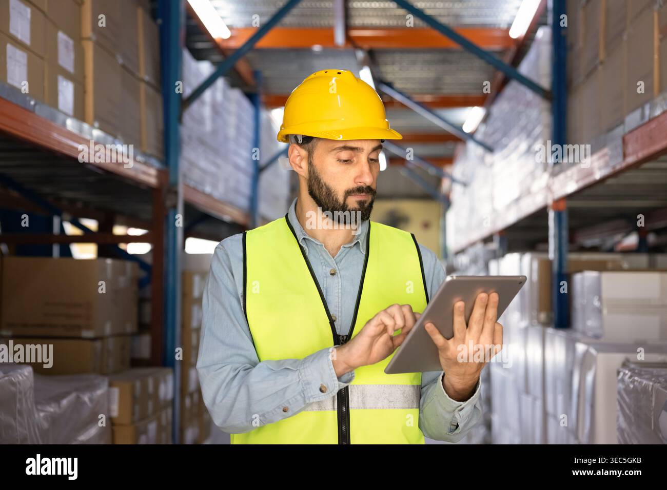 Warehouse worker using digital tablet for inventory management Stock Photo