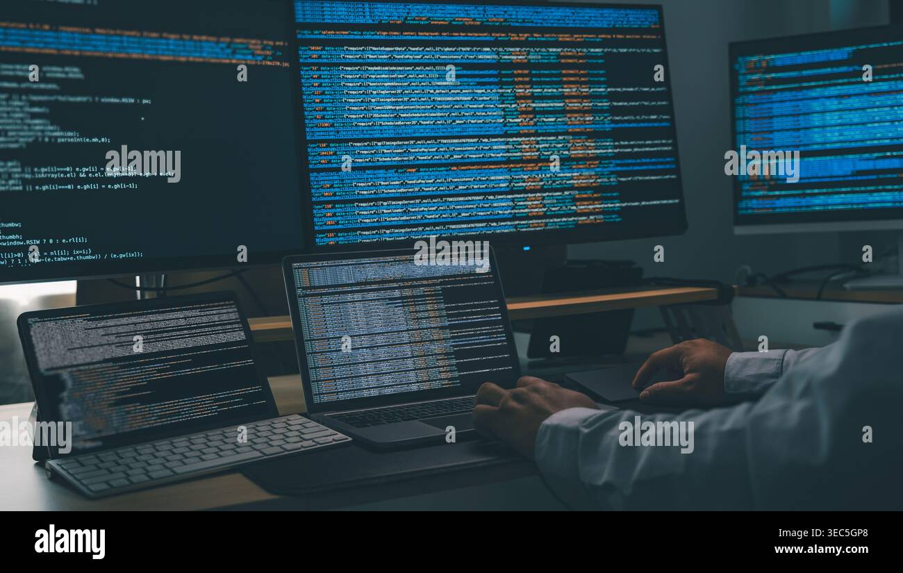 Man using AI chatbot while coding at a multi monitor workstation with laptop and screens displaying scripts, showing software development, automation Stock Photo