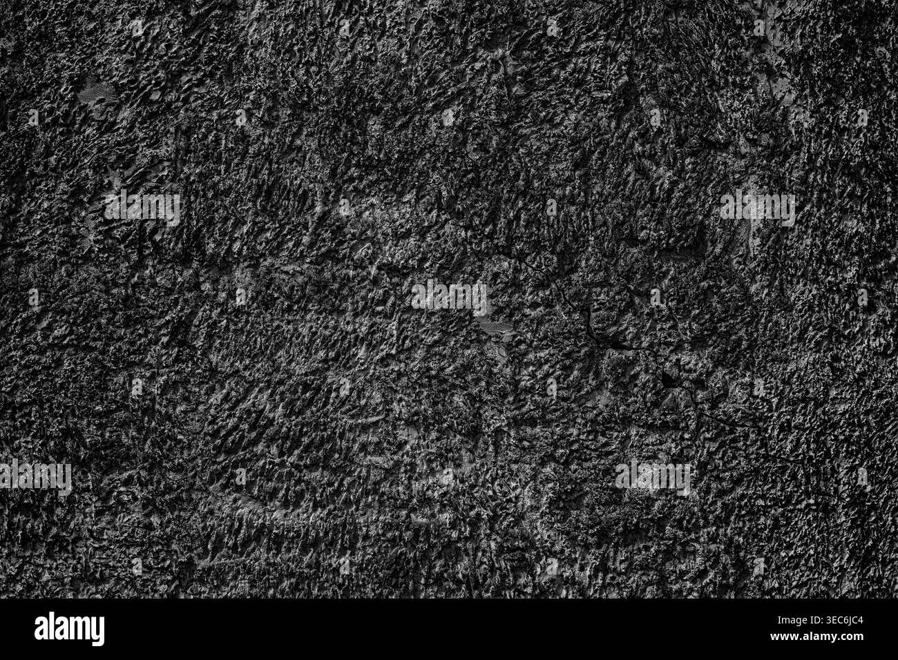 Cracked black textured plaster wall. Dark abstract background Stock Photo