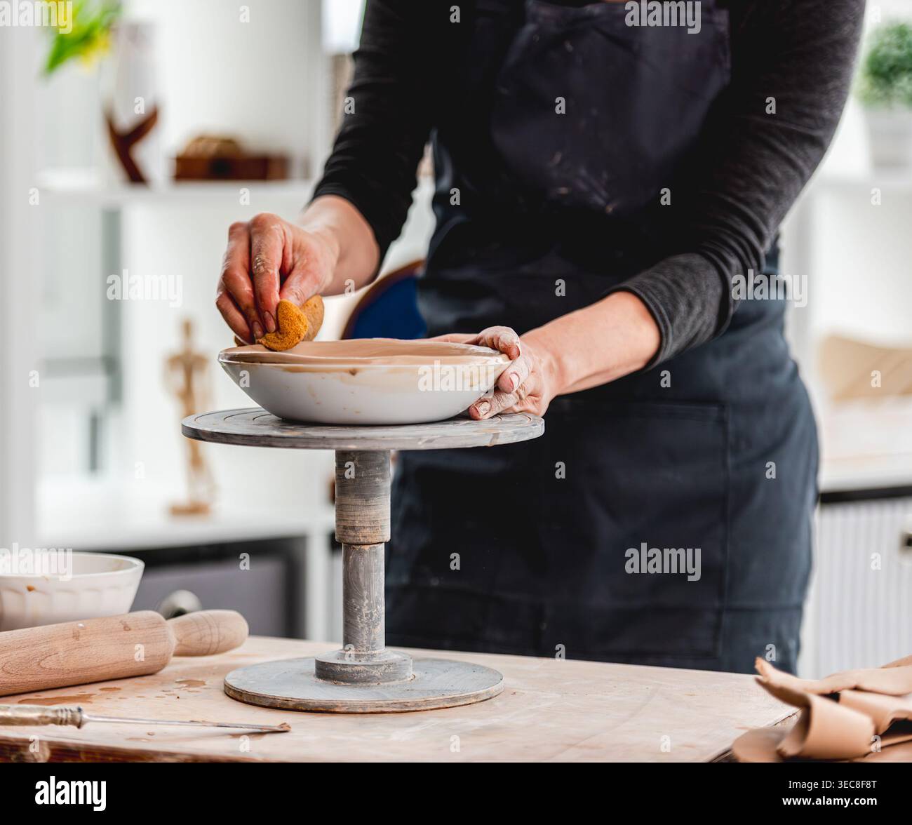 Close-Up Of Woman's Hands Making Clay Plate In Ceramics Workshop Stock Photo