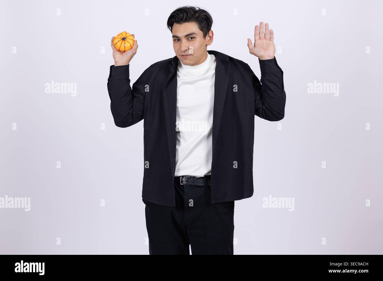 Surprised young man holding a donut and looking away in shock Stock Photo