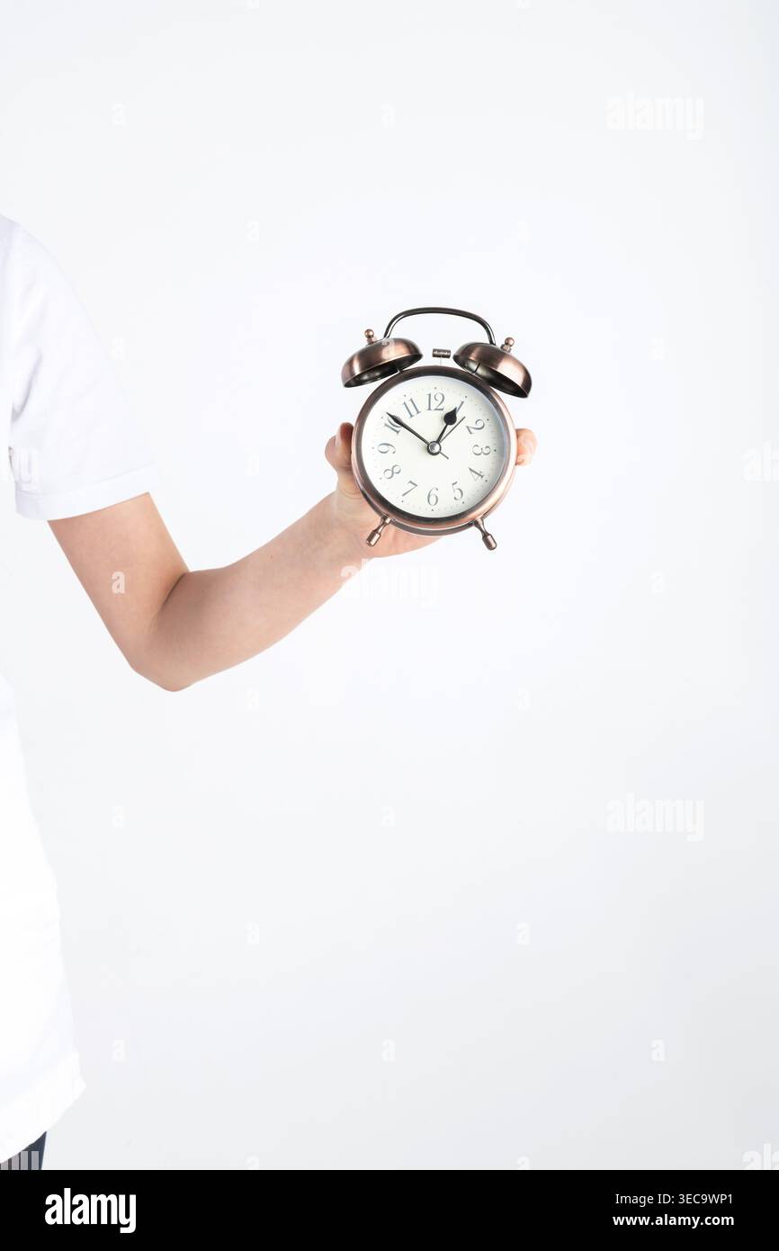 Hand holding a vintage alarm clock symbolizing punctuality and deadlines Stock Photo