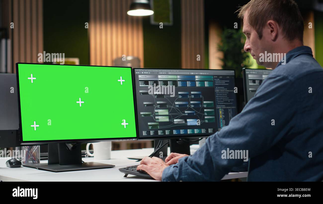 Green screen PC used by Silicon Valley company developer in office developing apps. Worker using deep learning tech on chroma key computer at work to debug applications and resolve issues Stock Photo