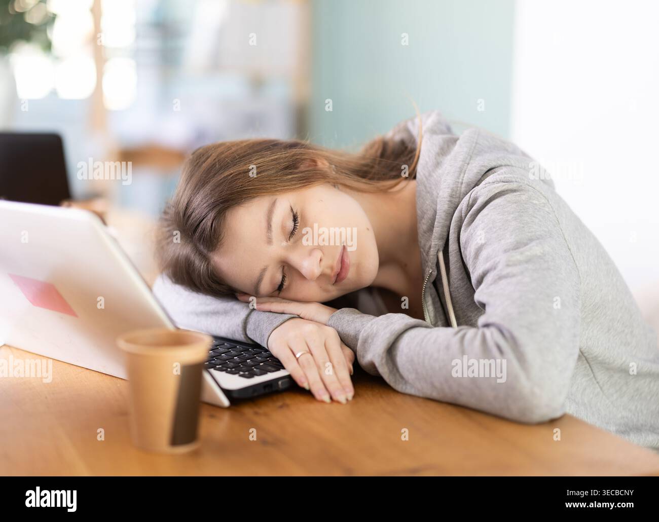 Tired young woman working with laptop Stock Photo