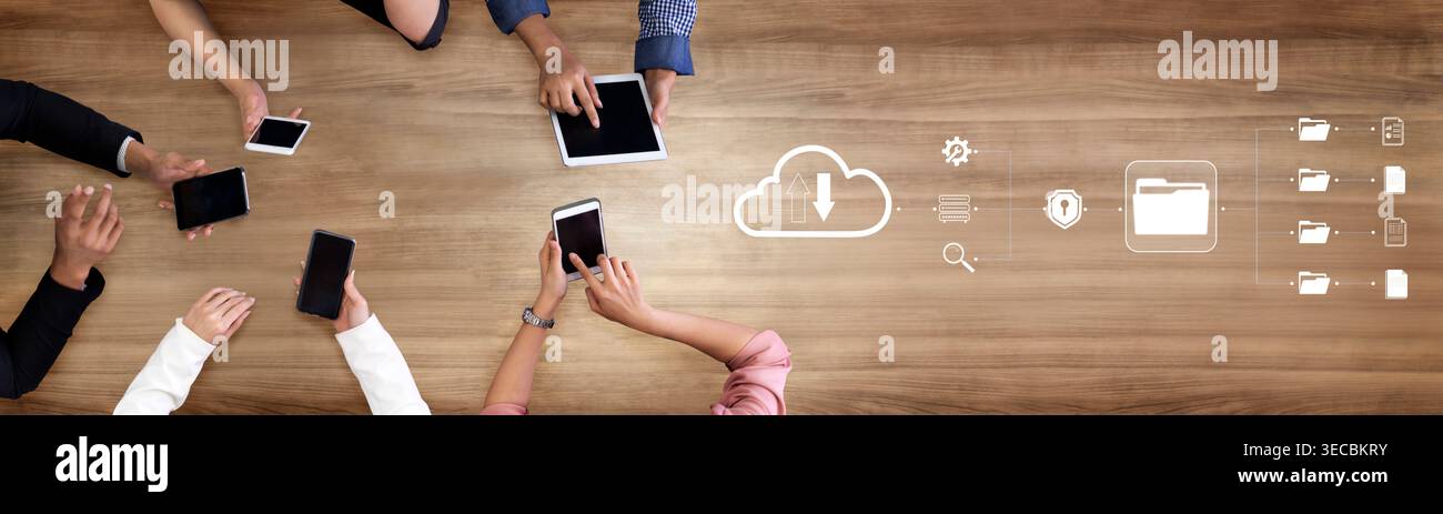 Collaborative Technology Workspace with Hands Holding Tablets and Smartphones on Wooden Table Representing Cloud Computing and Data Management Concept Stock Photo