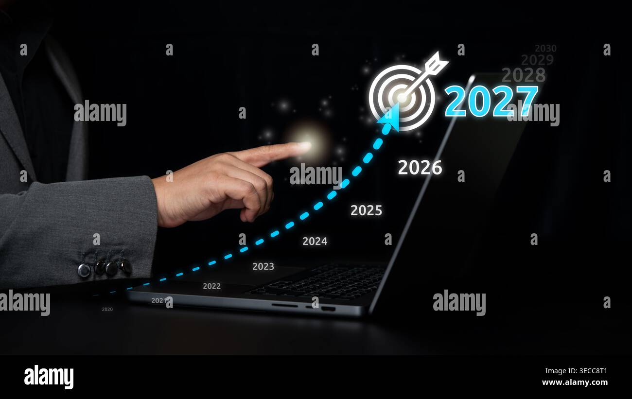Hand points at a glowing 2027 target icon above laptop, combining ...