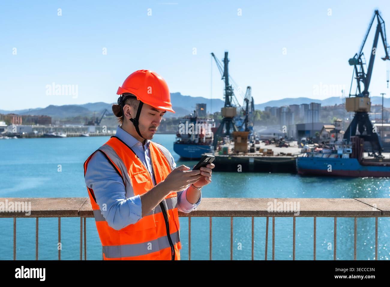 Cargo port worker using smartphone checking logistics Stock Photo