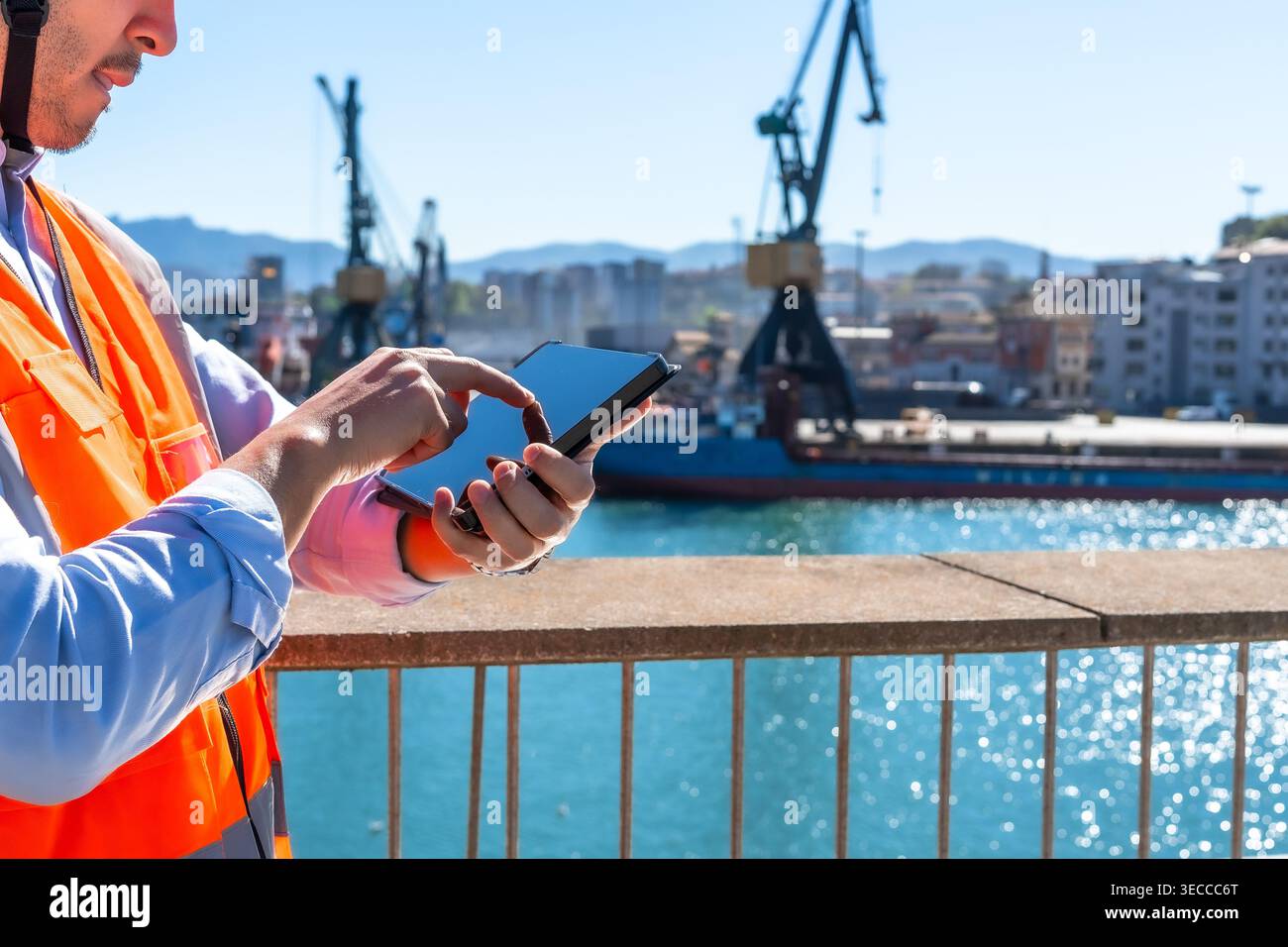 Cargo port worker using tablet managing logistics outdoors Stock Photo