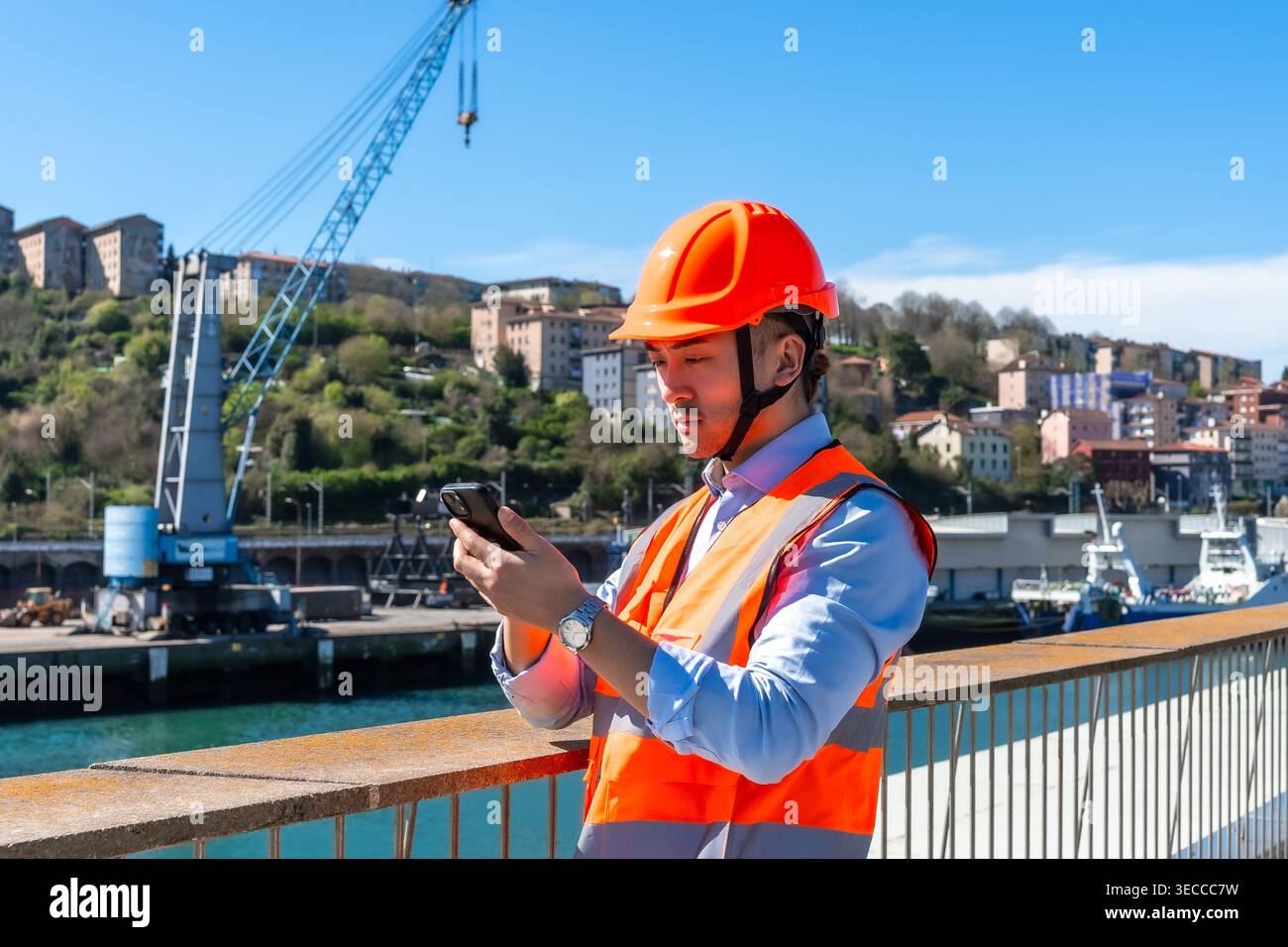 Young engineer using smartphone at cargo port Stock Photo