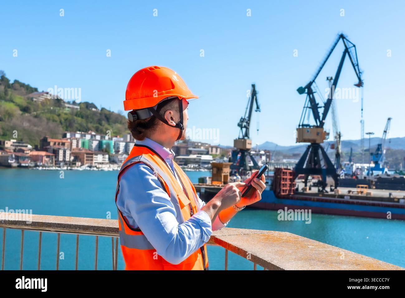 Port worker managing logistics using mobile phone Stock Photo