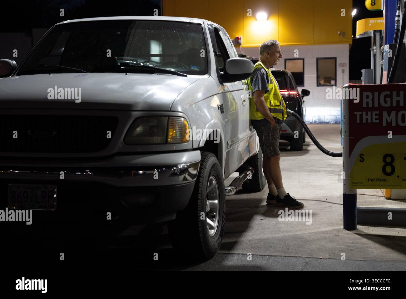 A person waits while filling their fuel tank at an Astro gas station on ...