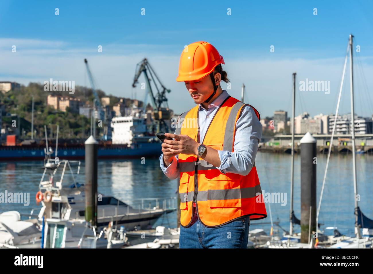 Port worker using smartphone managing logistics and shipping operations Stock Photo