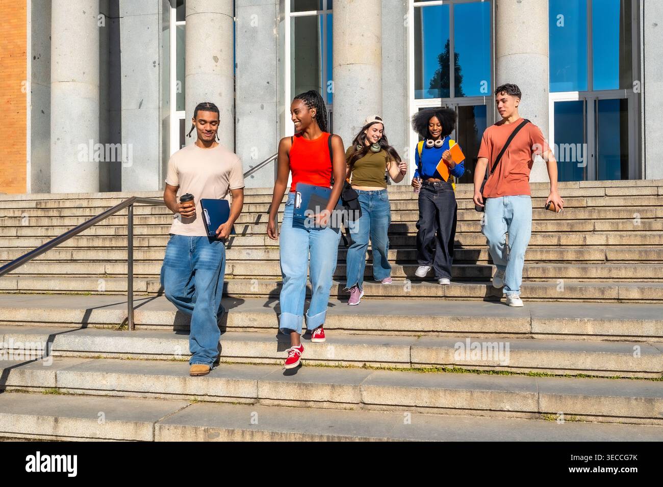 Diverse university students walking down campus stairs after class Stock Photo