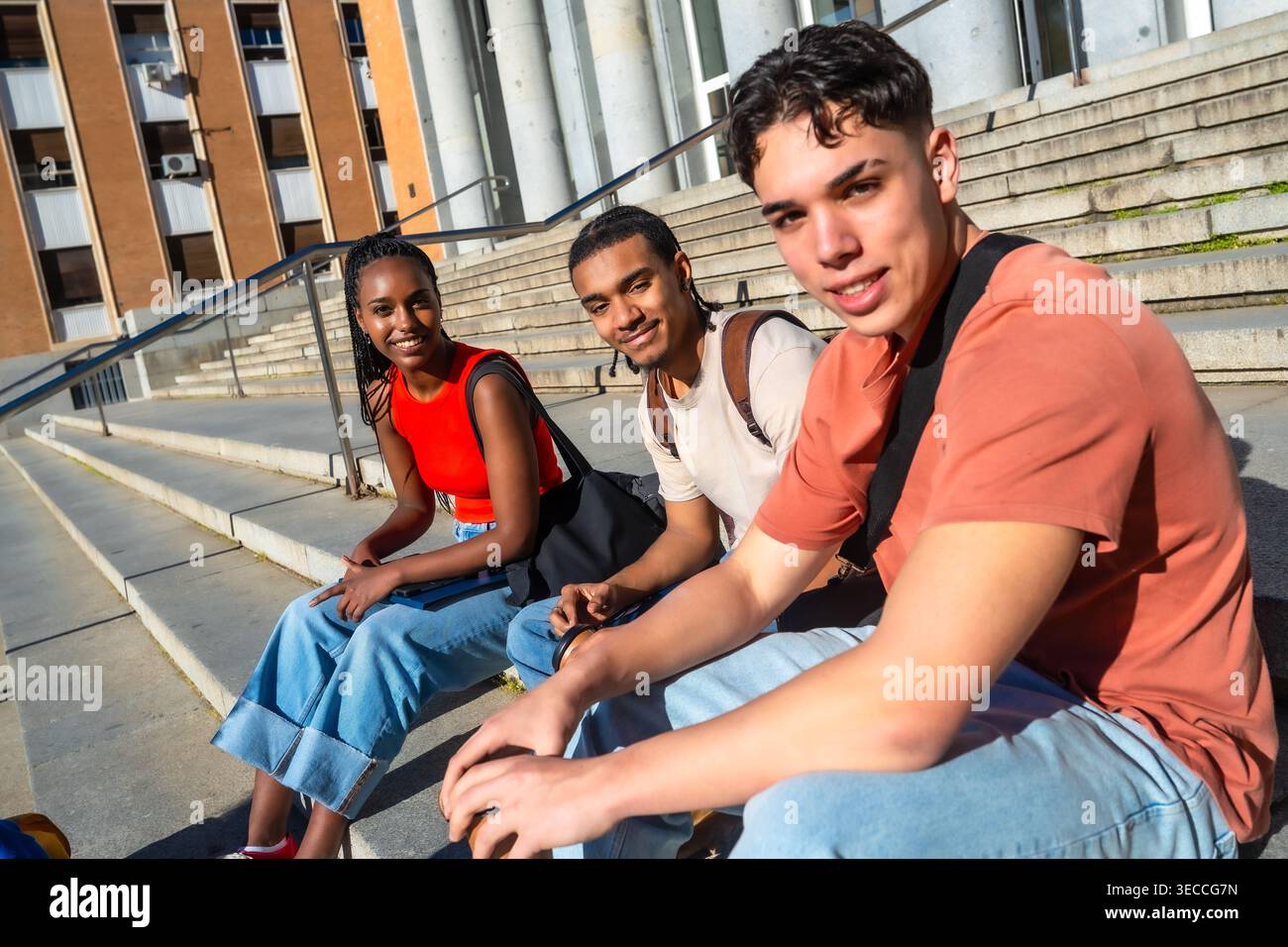 Diverse students sitting on campus stairs studying together Stock Photo