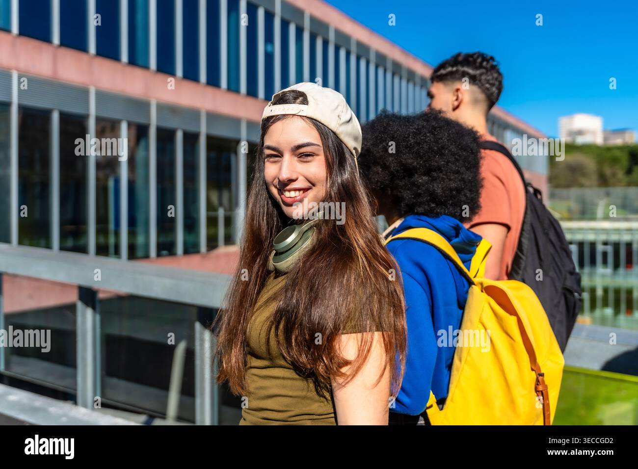 Diverse students walking on university campus smiling Stock Photo