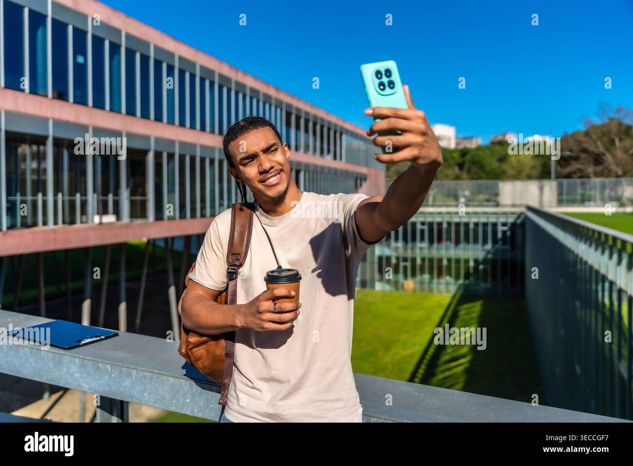 University student taking selfie with smartphone on campus Stock Photo