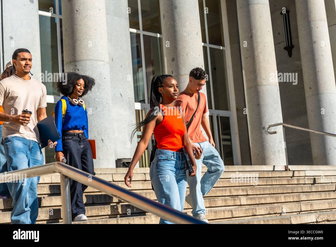 Diverse university students walking down campus stairs Stock Photo