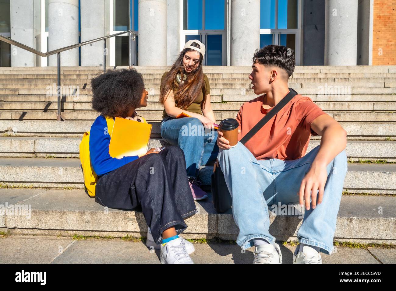 Diverse students conversing on university campus stairs Stock Photo