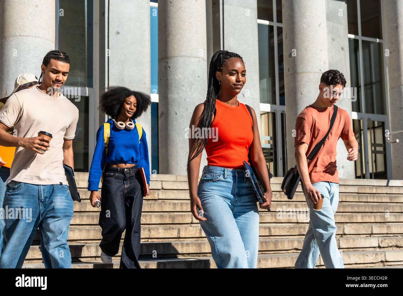 Diverse students walking down university campus stairs Stock Photo