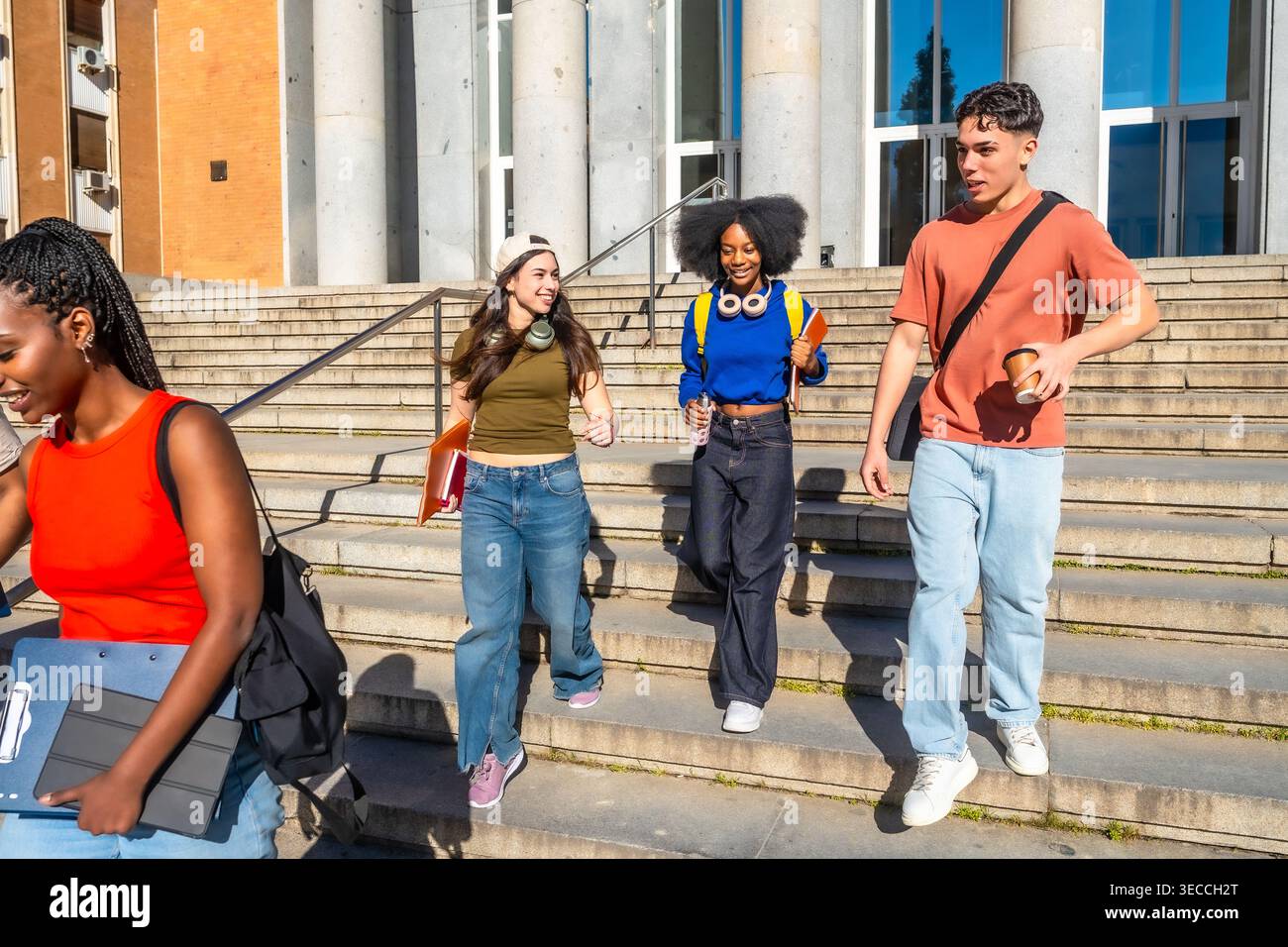 Multi ethnic students walking down university campus stairs Stock Photo