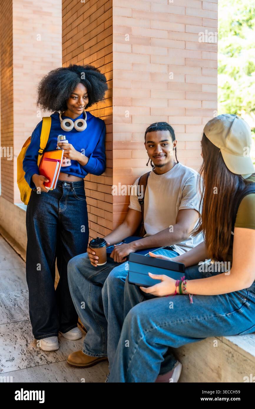 Diverse students conversing on university campus during break Stock Photo