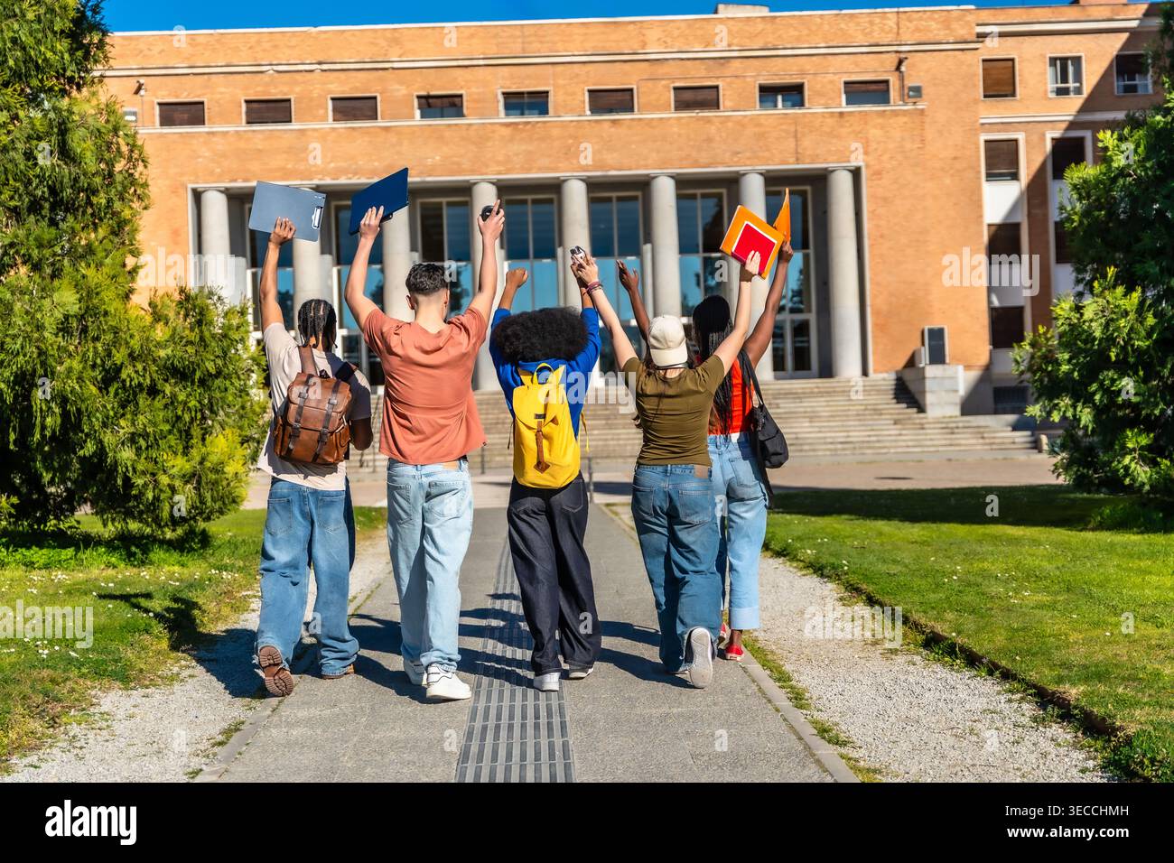 Diverse students celebrating success on university campus Stock Photo